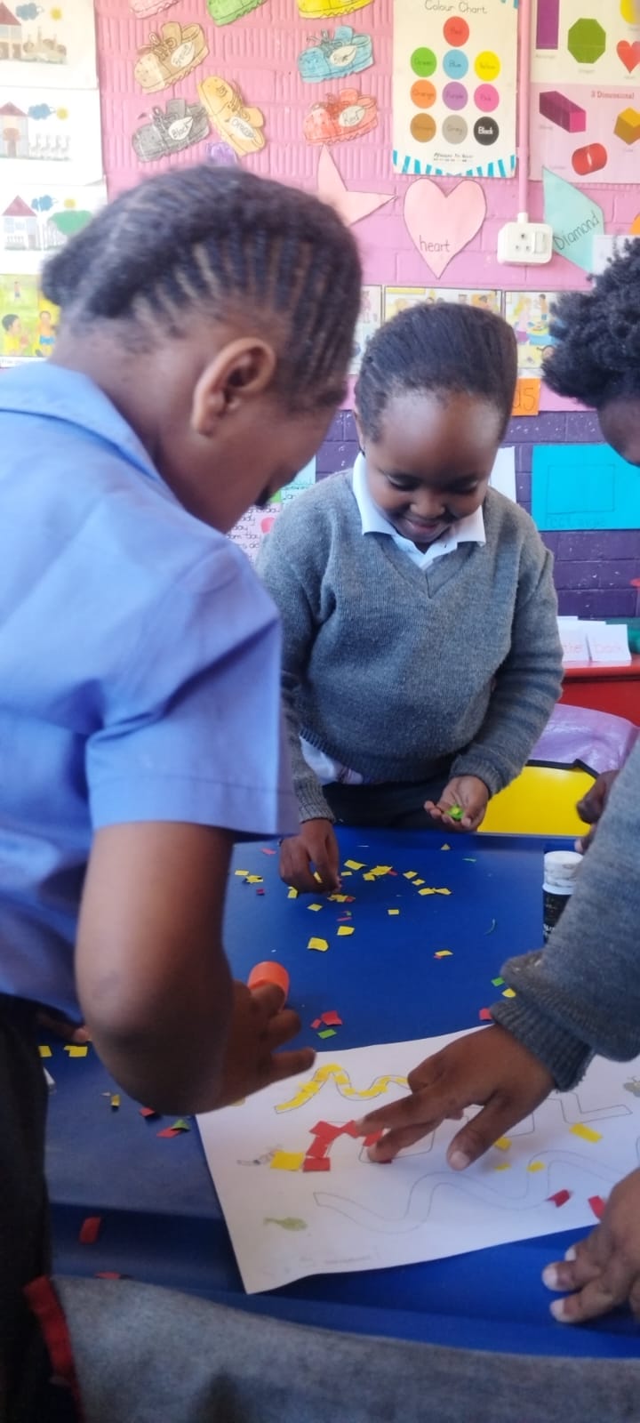 Two learners working together on a creative collage activity