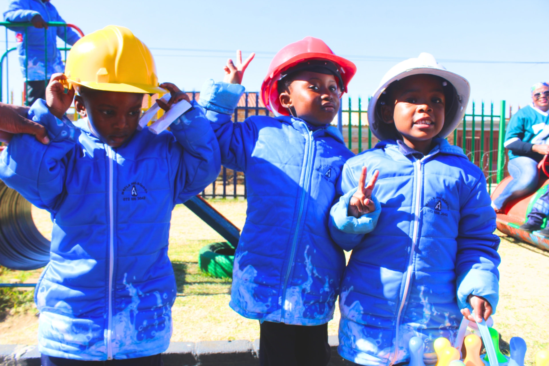 Three learners in hard hats posing during a careers and community helpers day