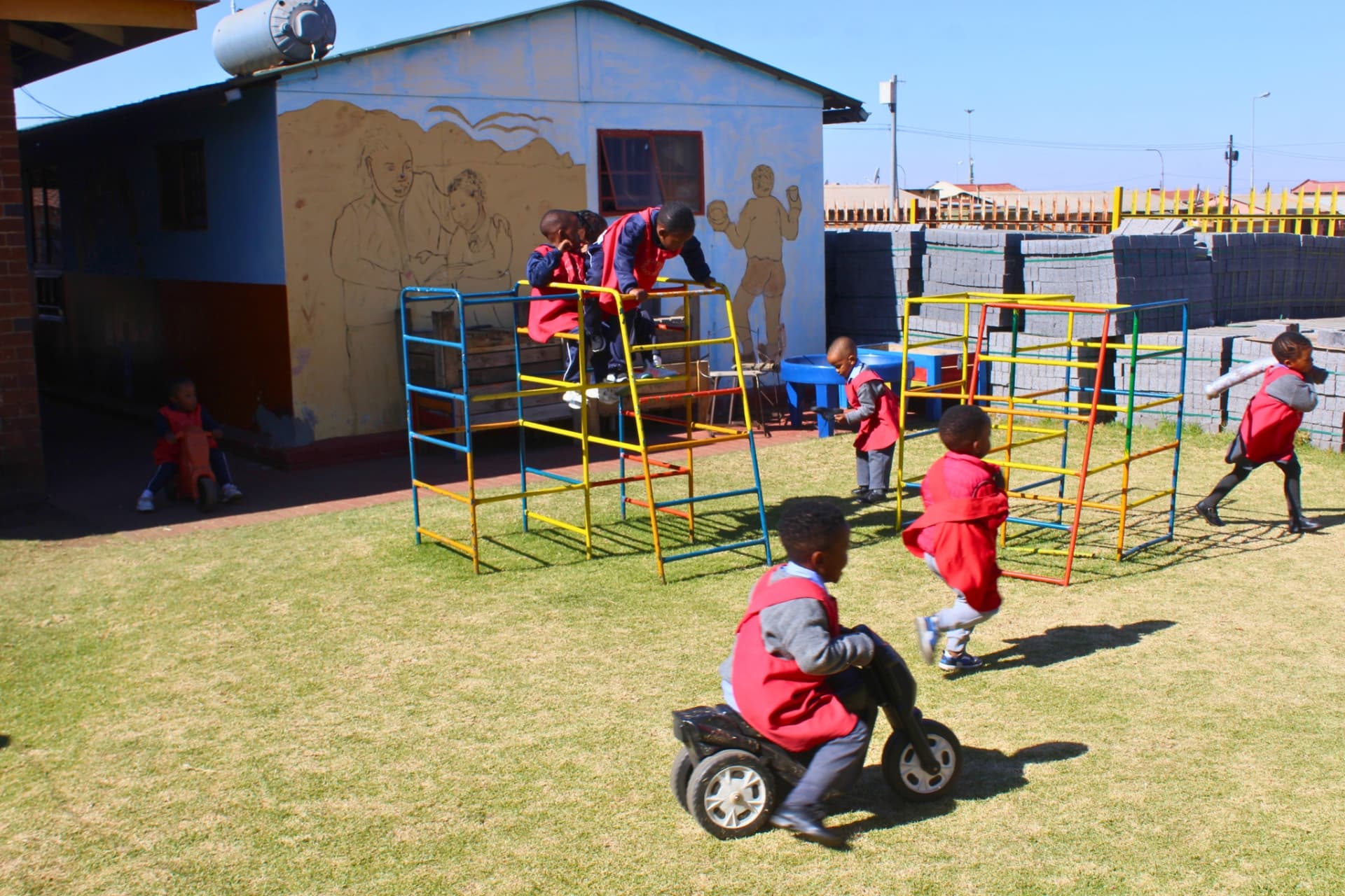 Children climbing the jungle gym and riding bikes on the school playground